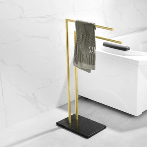 porte serviette sur pied dore une serviette grise vers droite